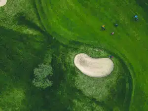 Golf basics for beginners: Aerial shot of a golf course bunker and green fairways.