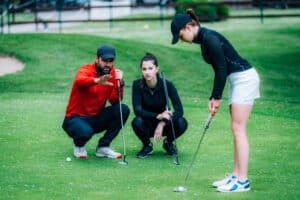 Golfing in Phuket: Golf instructor coaching players on putting technique.