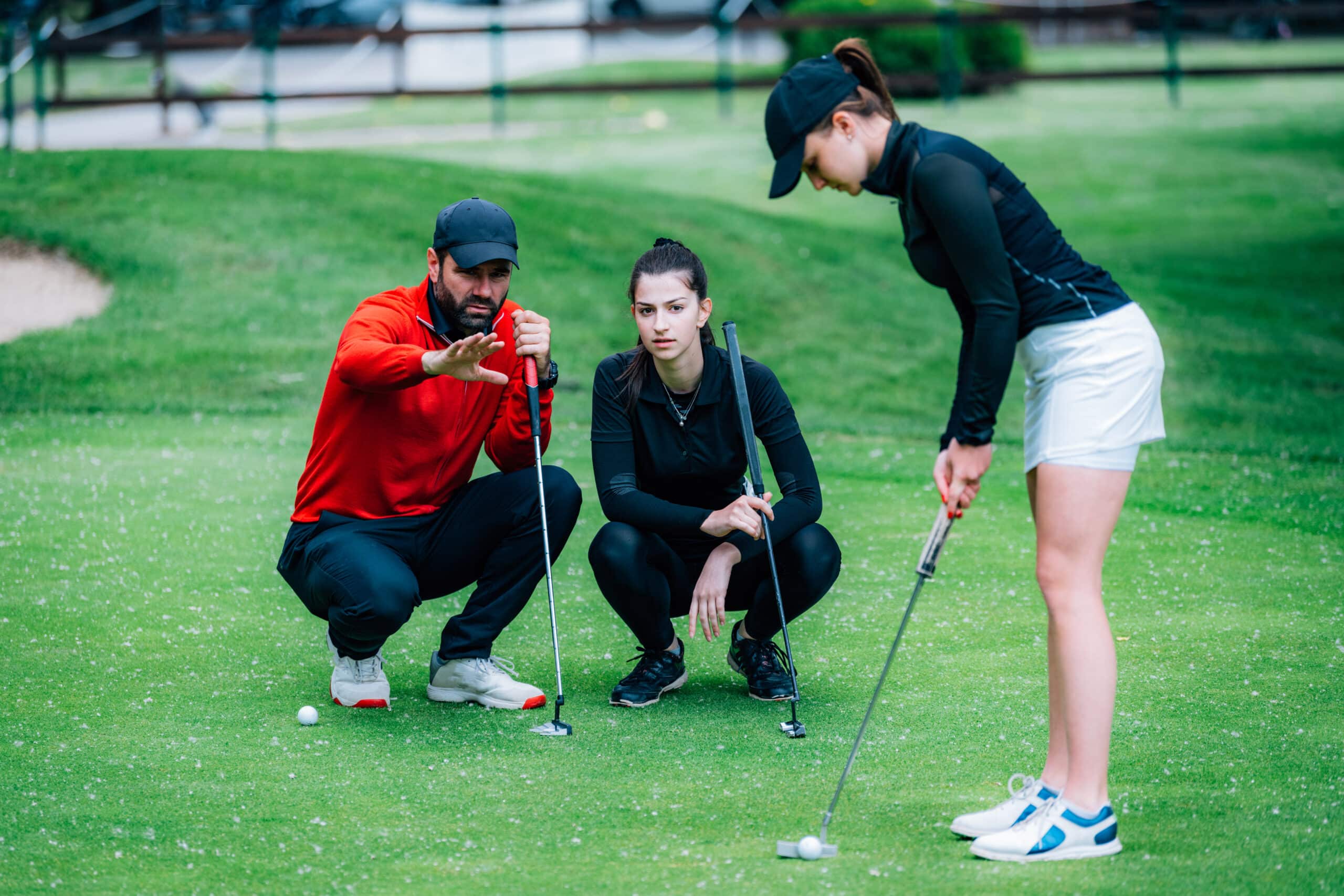 Golfing in Phuket – Best Courses, Resorts & Travel Tips 1 Golfing in Phuket: Golf instructor coaching players on putting technique.