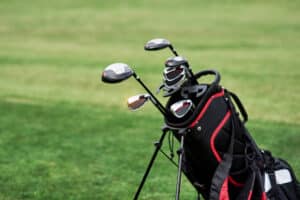 Types of golf clubs: A golf bag filled with clubs on a green fairway.