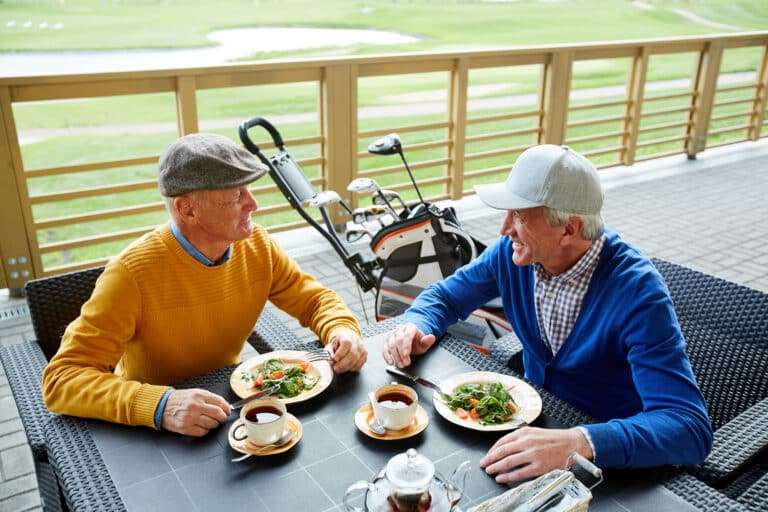 Golf in Laguna Phuket: Two senior golfers enjoying a meal at the clubhouse