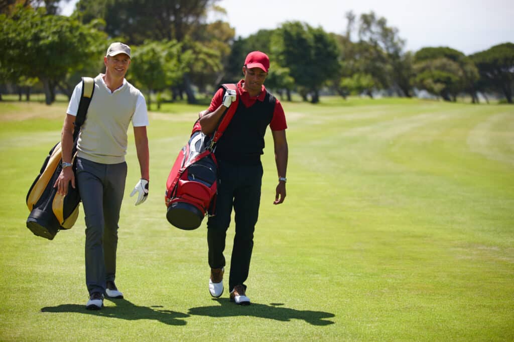 Best Month for Playing Golf in Phuket – When to Visit 1 Best month for playing golf in Phuket: Two golfers walking together on the fairway carrying their golf bags.