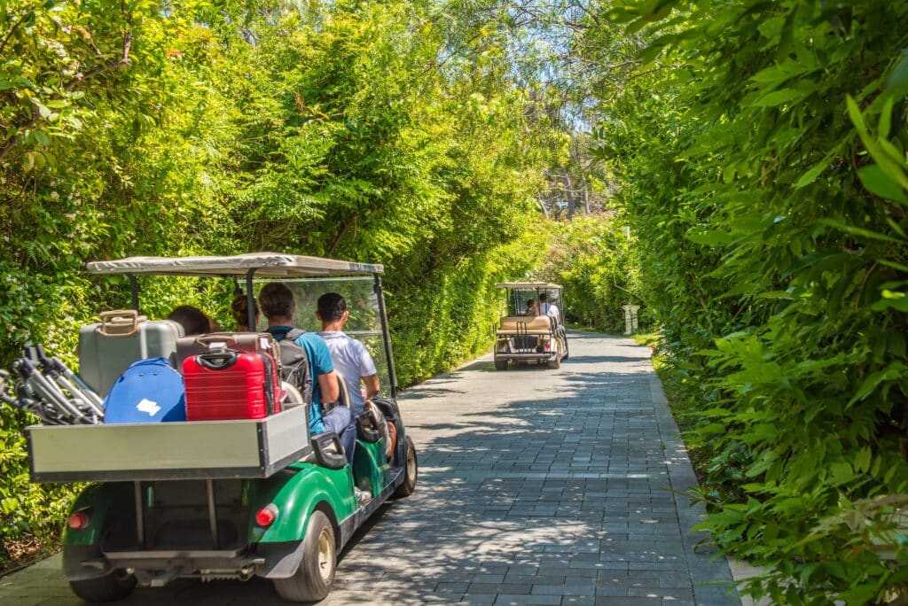 Things to Do on a Golf Holiday in Phuket – Relax & Explore 1 Things to do on a golf holiday in Phuket: Golf carts transporting people and luggage on a scenic path.