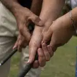 Phuket golf grip lessons: Close-up of a golf instructor adjusting a student's grip on a golf club.