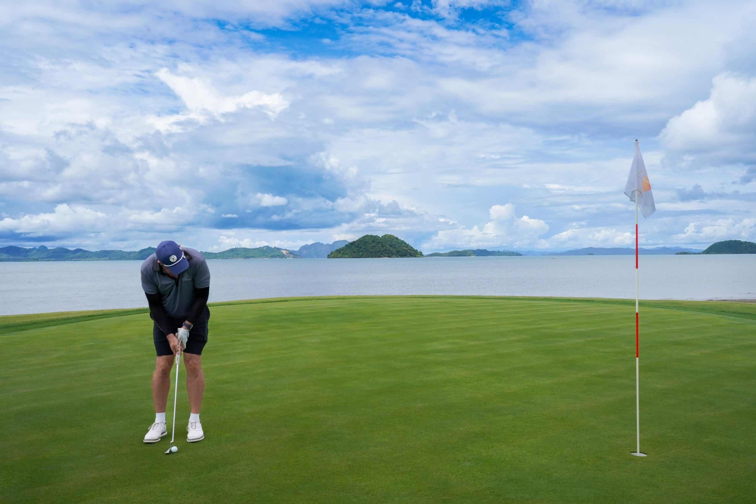 About 2 An expansive aerial view of Laguna Golf Course in Phuket, showcasing vibrant fairways, water features, and nearby coastal villas.